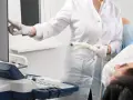 Arzt mit Ultraschallsonde und Patientin bei gynäkologischer Untersuchung.