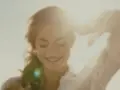 Lächelnde Frau im Sonnenlicht mit erhobener Hand.