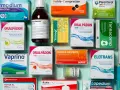 Medikamentenpackungen und eine Flasche Saft gegen Durchfall, auf blauem Hintergrund.