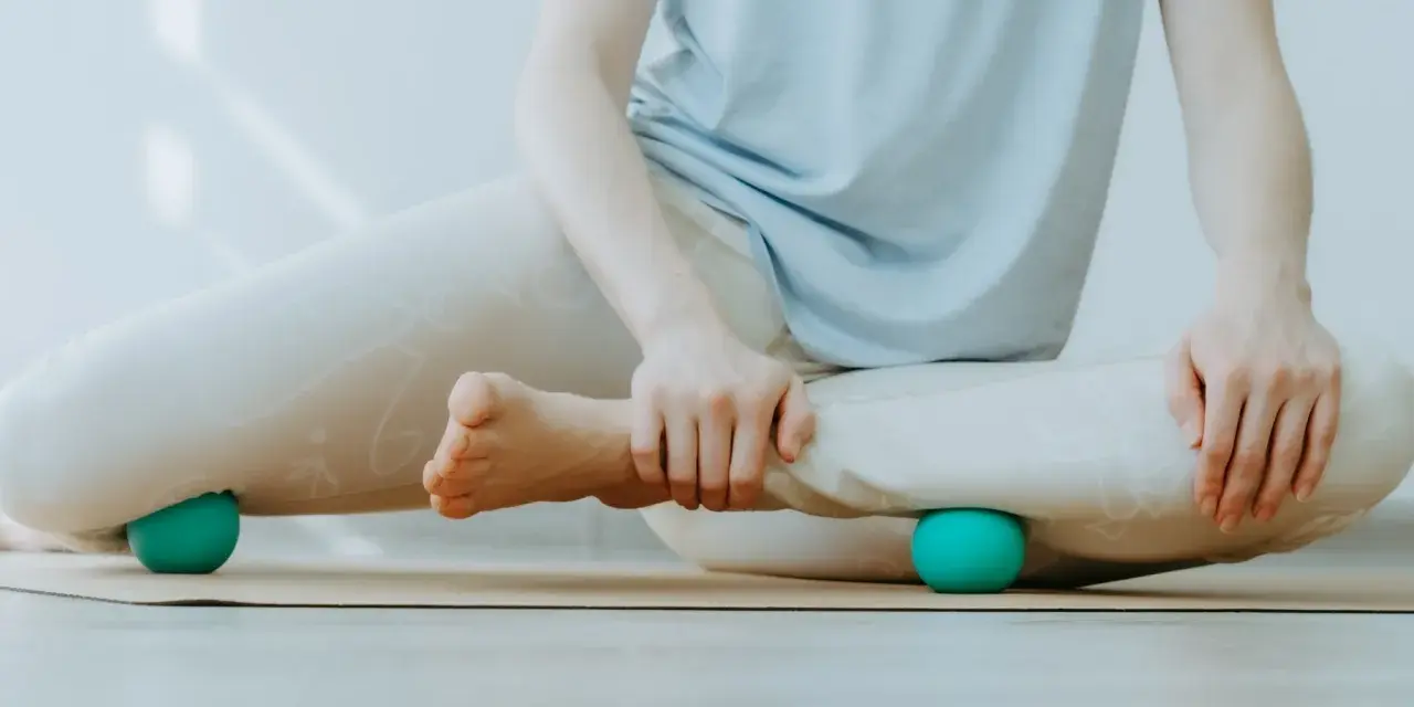 Person massiert Beine mit Faszienball. Hilft bei was sind Faszien Schmerzen.