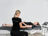Physiotherapeutin führt Ultraschalltherapie an einem Arm durch. Die Krankenkasse übernimmt die Kosten für diese Behandlung.