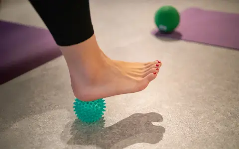 Fußmassage mit Igelball zur Linderung einer gereizten Achillessehne.