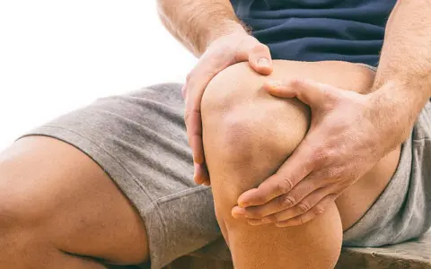 Mann hält schmerzendes Knie. Schmerzen beim Knien auf hartem Boden sind deutlich zu sehen.