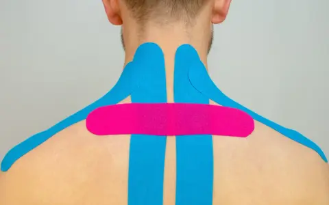 Nacken tapen bei Verspannungen: Blaues und pinkes Kinesio-Tape zur Linderung von Nackenschmerzen und Verspannungen.