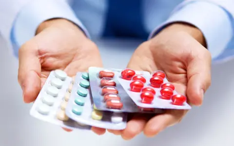 Hände halten Blisterpackungen mit Medikamenten. Möglicherweise zur Linderung von Nervenschmerzen.