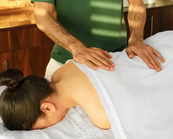 Hände eines Masseurs auf dem Rücken einer Frau, die verschiedene arten von massagen demonstrieren. Entspannung und Wohlbefinden.