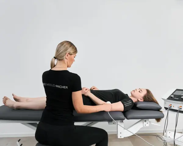 Physiotherapeutin führt Ultraschalltherapie an einem Arm durch. Die Krankenkasse übernimmt die Kosten für diese Behandlung.