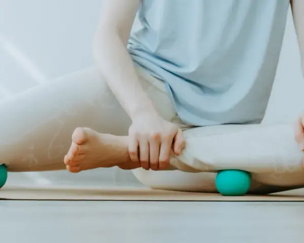 Person massiert Beine mit Faszienball. Hilft bei was sind Faszien Schmerzen.
