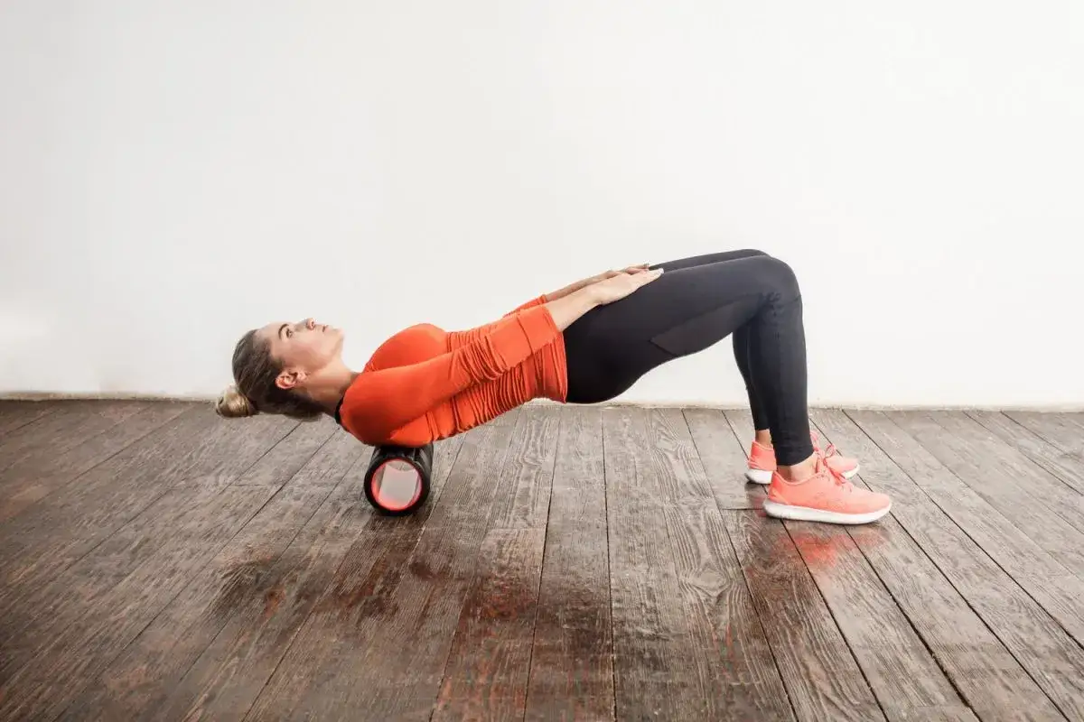Frau nutzt Foam Roller für Physiotherapie bei Verspannungen im Rücken.