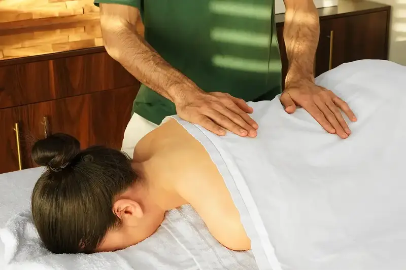 Hände eines Masseurs auf dem Rücken einer Frau, die verschiedene arten von massagen demonstrieren. Entspannung und Wohlbefinden.