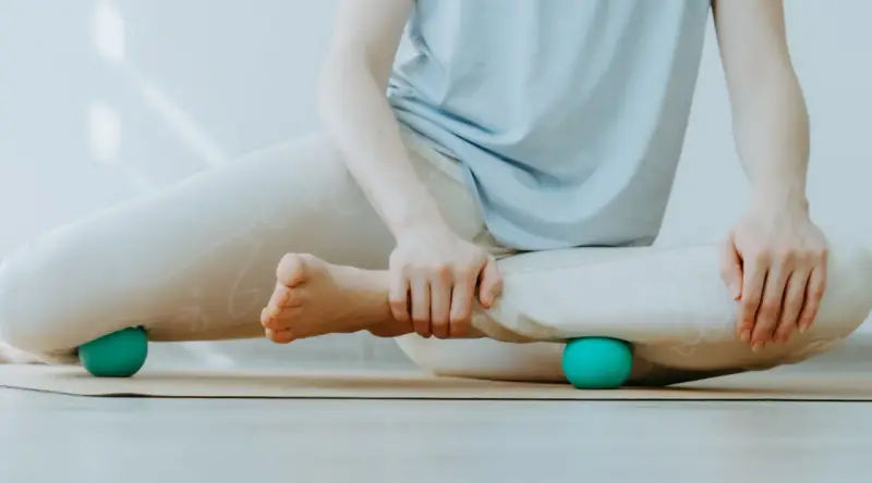 Person massiert Beine mit Faszienball. Hilft bei was sind Faszien Schmerzen.
